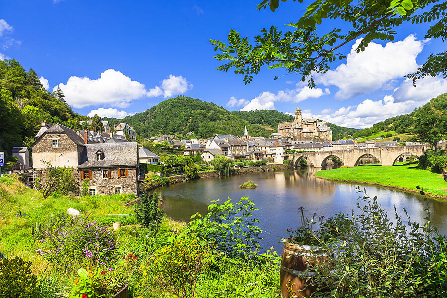 Schilderachtig uitzicht op een typisch dorp in de Périgord met een stenen brug, rustige rivier en traditionele huizen, vlakbij een natuurcamping in de regio Périgord.