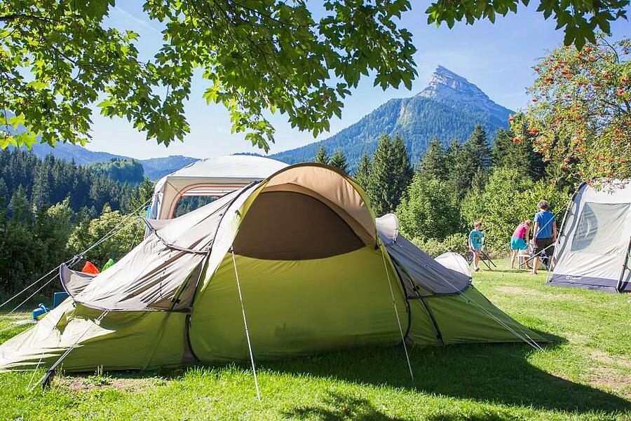 Kampeerplaats met tent aan de voet van de bergen in de Isère, midden in een ongerepte natuur – perfect voor een gezinsvakantie in de buitenlucht.