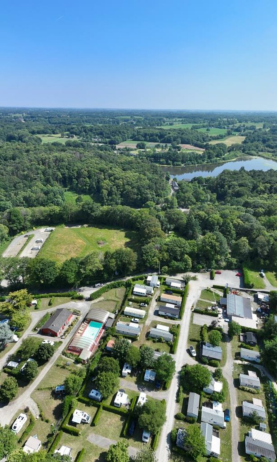 Luchtfoto van een 3-sterrencamping in Frankrijk met stacaravans, zwembad en natuur, ideaal voor gezinsvakantie.