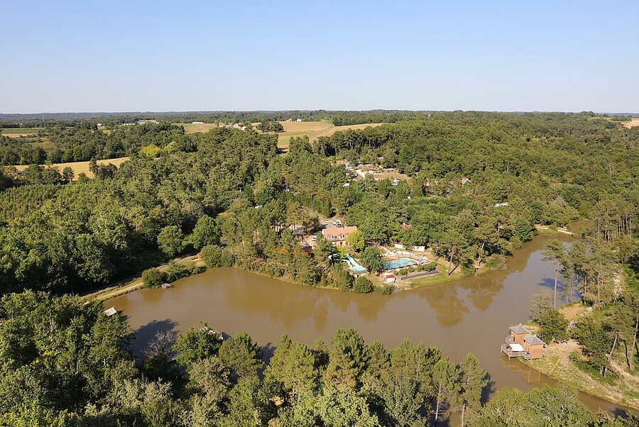 Luchtfoto van Domaine de l’Étang de Bazange, een camping in de Dordogne, verscholen in het hart van het bos met een vijver en een zwembad.