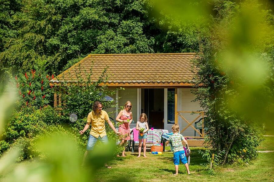 Echtpaar en twee kinderen spelen voor hun stacaravan