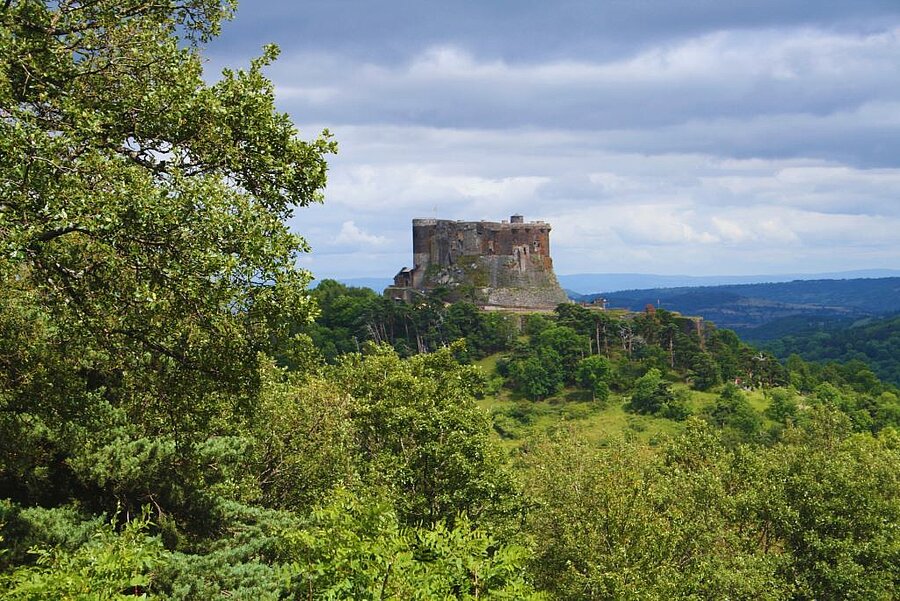 Luchtfoto van het kasteel van Murol met uitzicht op de vallei, omringd door bossen en typische dorpen van de Auvergne.