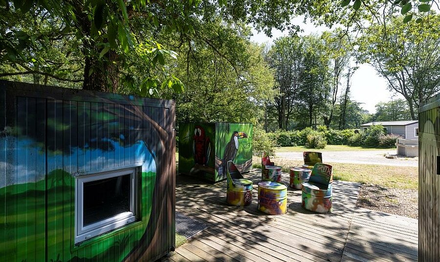 Schaduwrijke relaxplek met street-art in de camping bij Lorient, op enkele stappen van de huuraccommodaties.