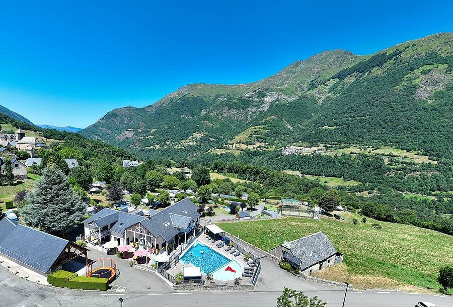 Luchtfoto van een camping bij Luz-Saint-Sauveur met verwarmd zwembad, omringd door bergen, ideaal voor een Camping Luz-Saint-Sauveur vakantie.
