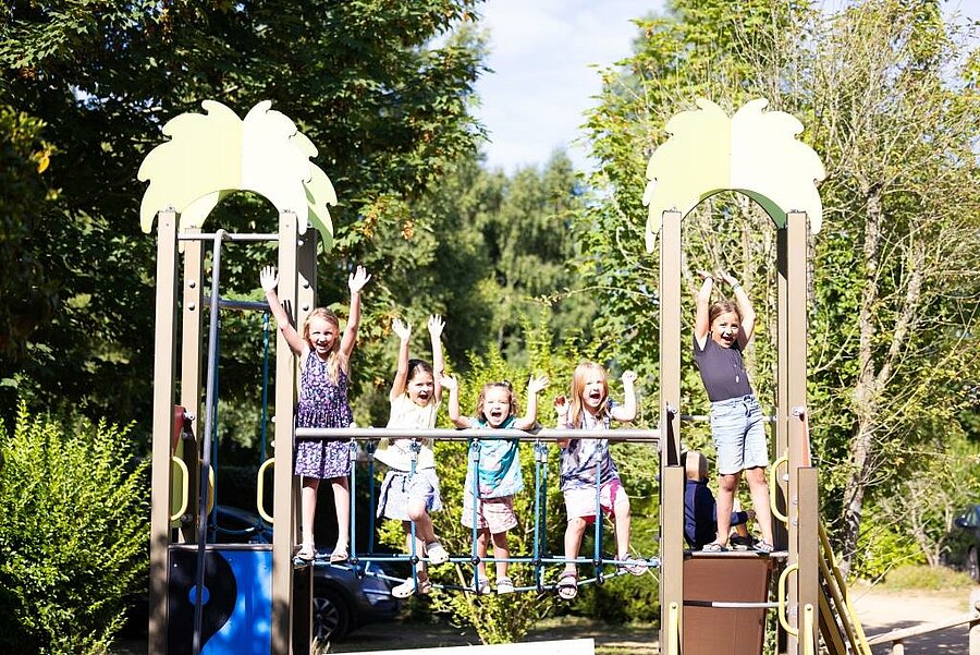 Kinderen die spelen op een speeltuin in een natuurlijke omgeving binnen een camping in Bretagne, ideaal voor gezellige en onvergetelijke familievakanties.