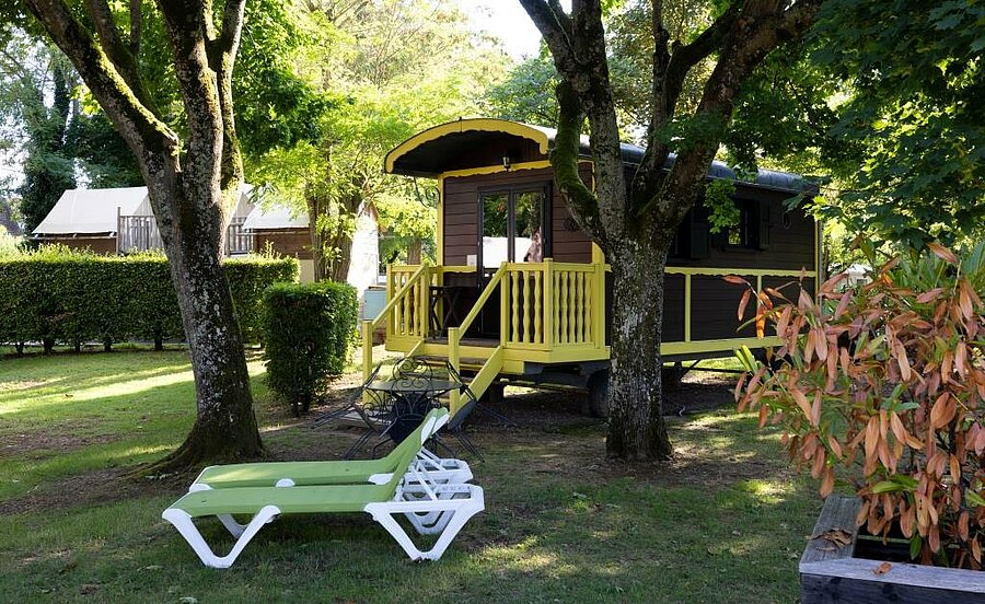 Houten pipowagen onder de bomen op een natuurcamping nabij de Sologne, origineel vakantieverblijf