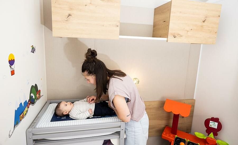 Mama verschoont haar baby in kampeeraccommodatie