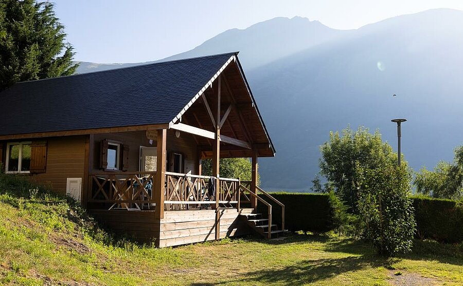 Houten chalet met terras op een campsite met uitzicht op de bergen van de Hautes-Pyrénées, perfect voor een ontspannende natuurvakantie.