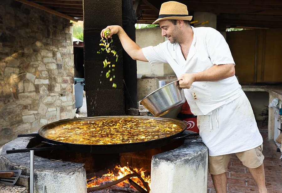 Bereiding van een traditioneel gerecht in de buitenlucht op een charme camping in de Languedoc-Roussillon, in een warme en authentieke sfeer