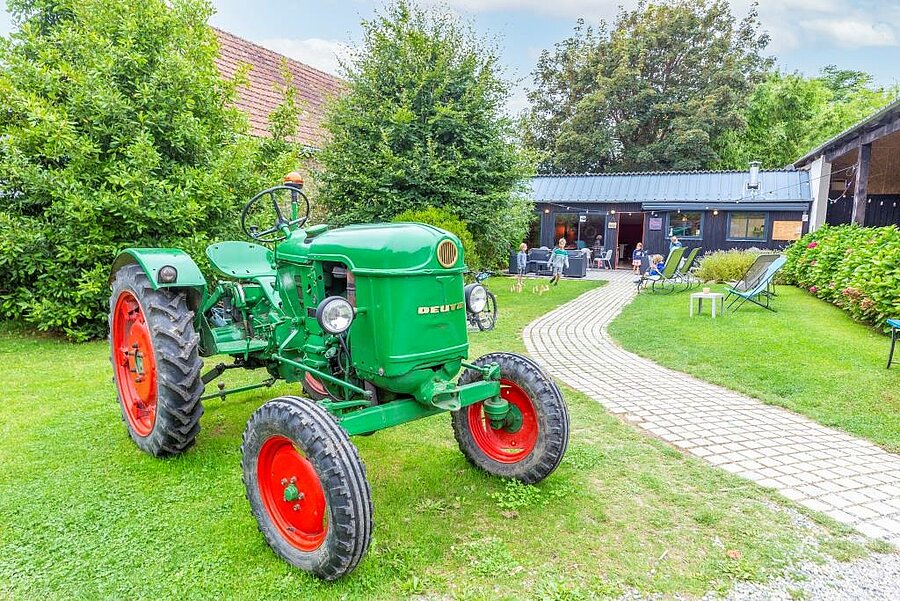 Groene vintage tractor op het gras van een gezellige camping nabij Concarneau, familiale sfeer in Bretagne.