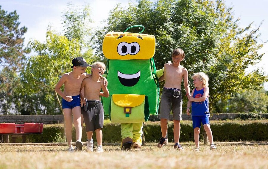 Kinderen hebben plezier met Pako, de mascotte van de campings Sites et Paysages in een groene omgeving, ideaal voor een gezinsvakantie vlak bij de kastelen van de Loire.