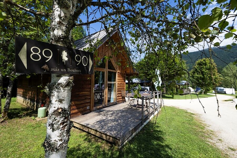Houten chalet in een groene omgeving op een camping, waar luxe, natuur en authenticiteit samenkomen voor een bijzondere vakantie.