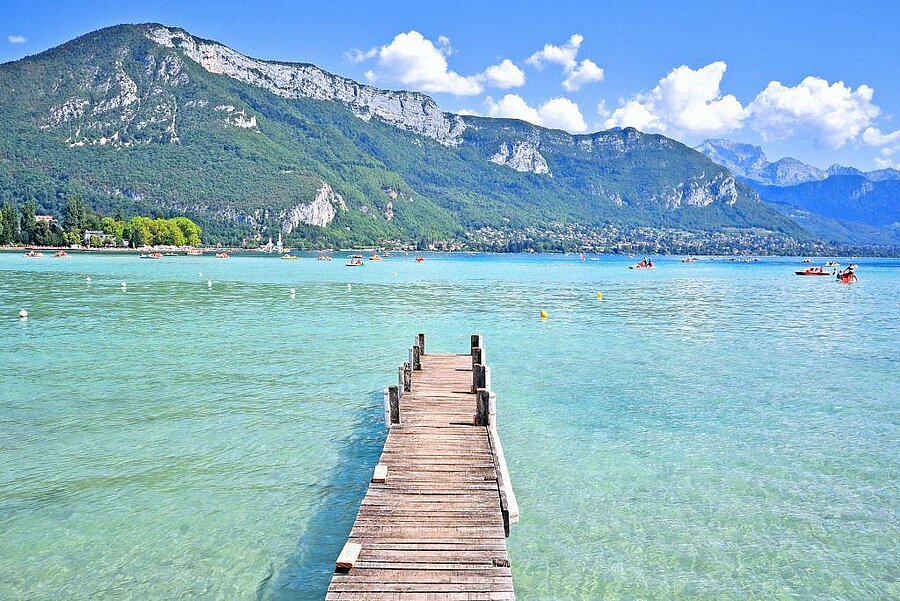 Houten steiger aan het meer van Annecy met helder water en bergen