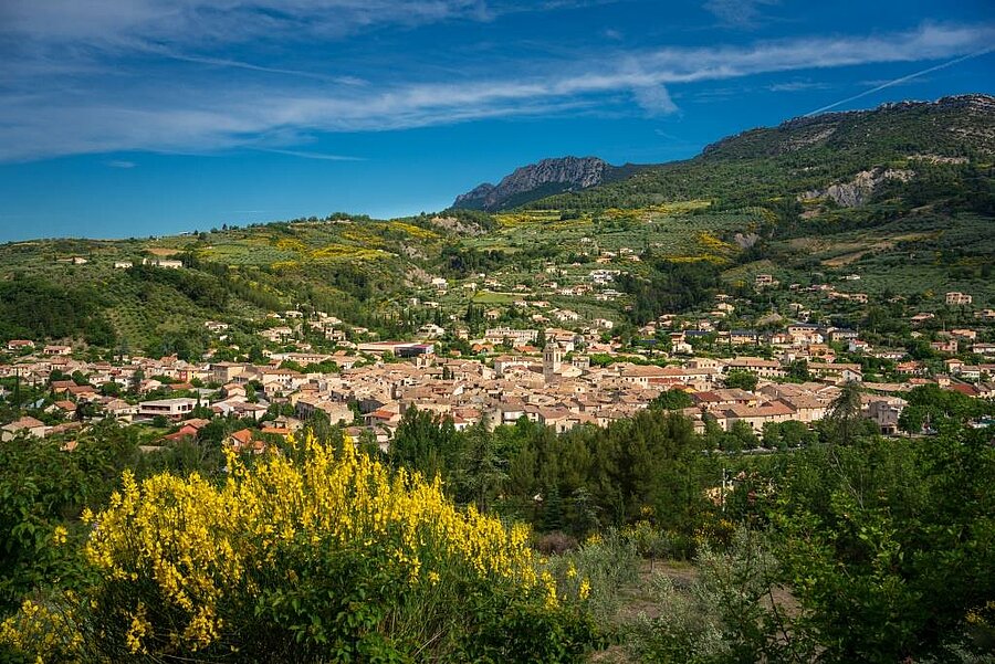 Panoramisch uitzicht op een dorp in de Drôme omgeven door groene heuvels, ideaal voor een charme-campsite verblijf
