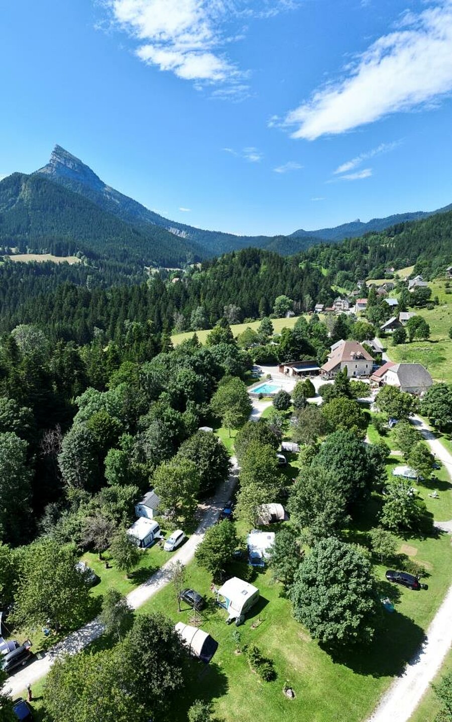 Luchtfoto van een Sites et Paysages camping, verscholen in de bergen, ideaal voor een natuurvakantie tijdens de meivakantie.