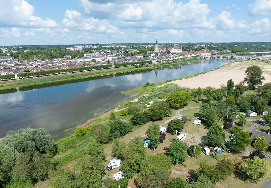 Luchtfoto van een groene camping aan de Loire, vlakbij de Sologne, met uitzicht op Gien en de iconische brug
