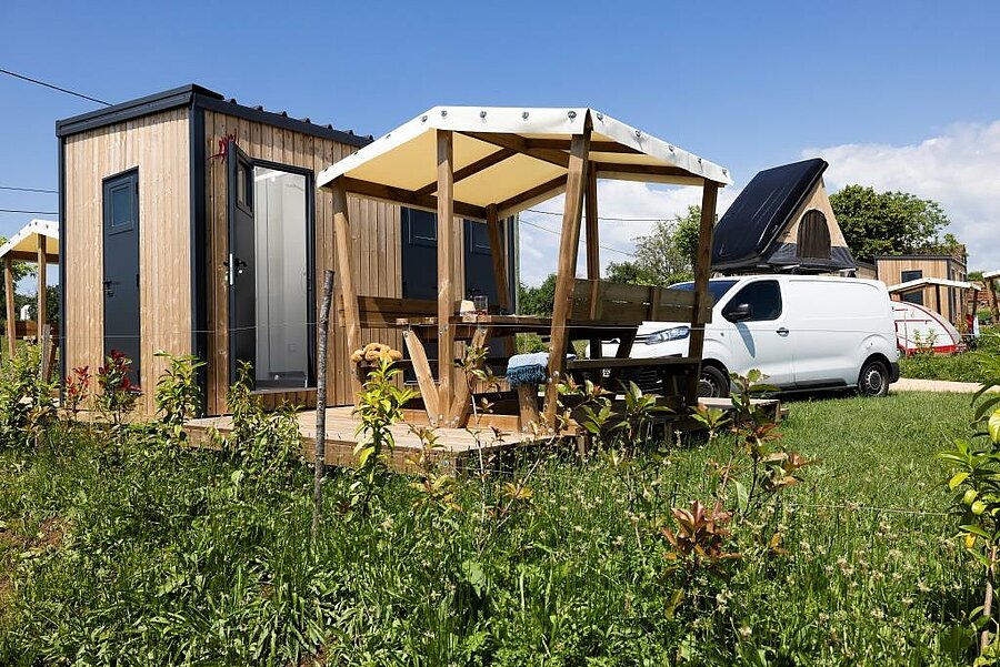 Comfortabele van-staanplaats met privé sanitair, tuinmeubilair en ingerichte van, op een charme camping in Frankrijk.