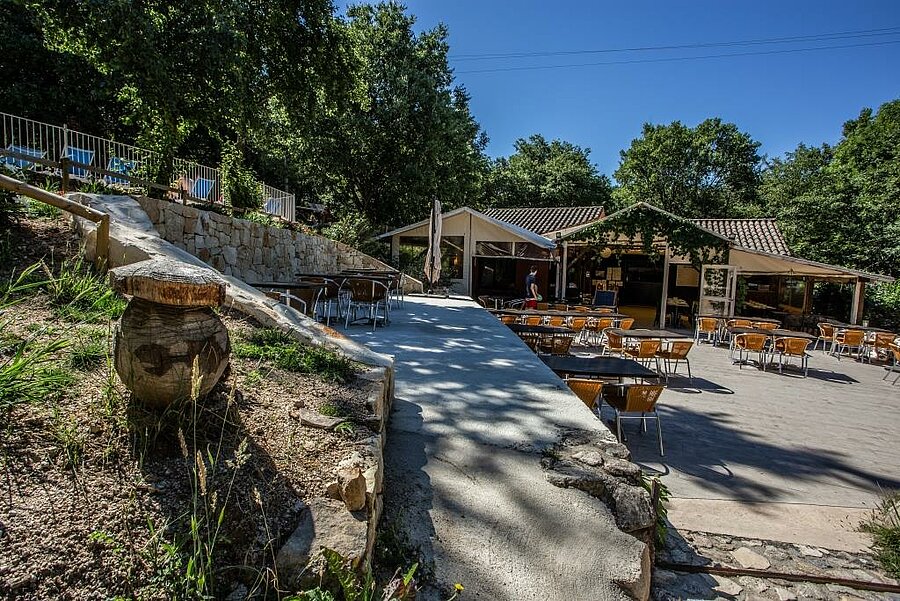 Buitenrestaurant met schaduwrijk terras op een camping in de Ardèche, midden in de natuur