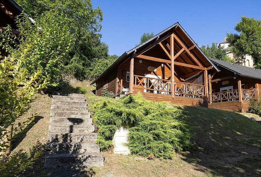 Comfortabele houten chalets op de heuvel van een camping, ideaal voor een luxe kampeervakantie midden in de natuur.
