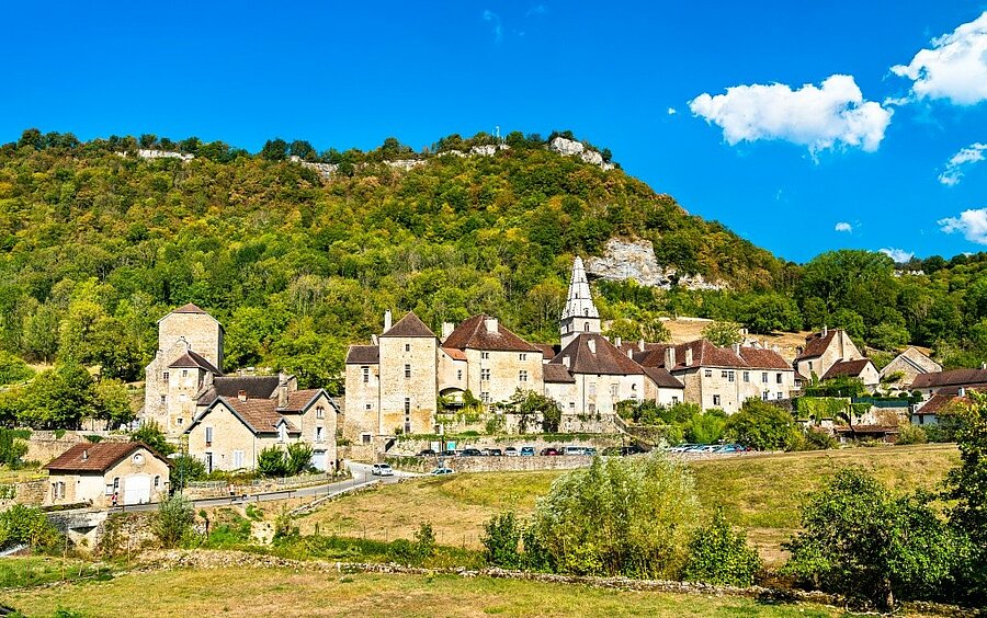 Baume-les-Messieurs aan de voet van de beboste rotsen van de Jura, te ontdekken tijdens een campingvakantie.