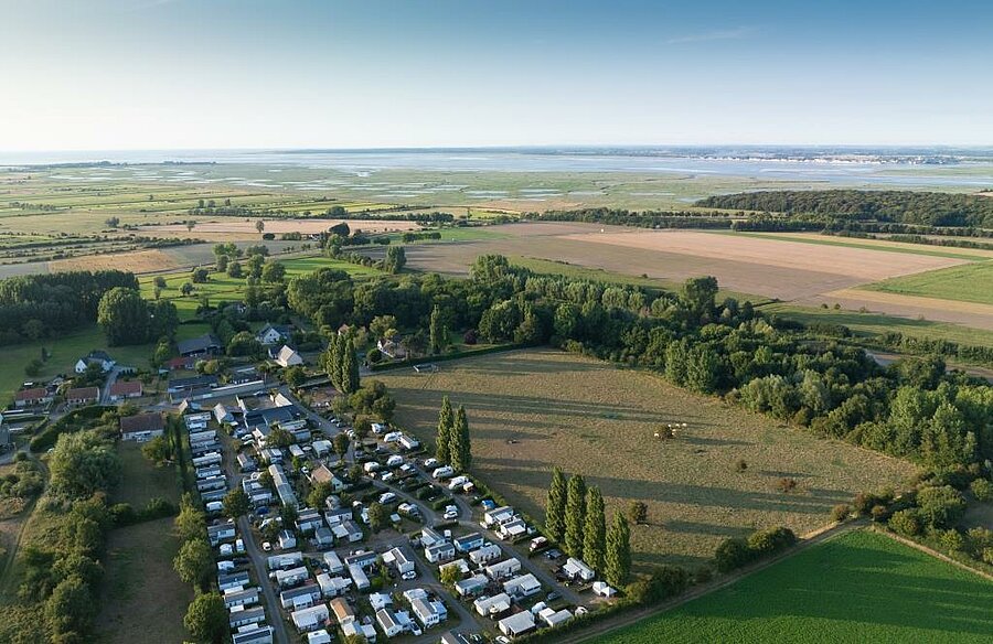 Luchtfoto van een camping in de Baai van de Somme, omringd door velden en moerassen, ideaal voor een gezinsvakantie aan het water.