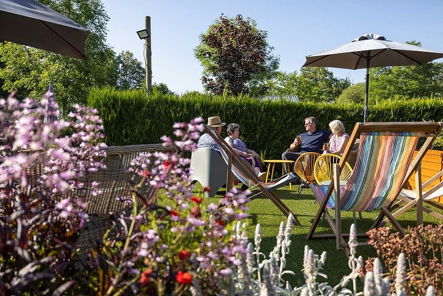 Stacaravan huren in Morbihan op de camping, snack- en eetruimte buiten met ligstoelen en parasols in Bretagne.