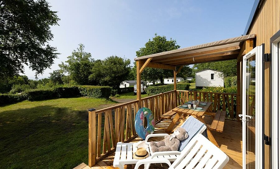 Houten terras van een stacaravan op camping Le Panoramic, comfortabele accommodatie nabij Moëlan-sur-Mer voor buitenleven.