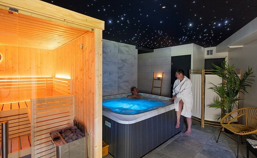 Wellnessruimte met sauna en privéspa in een natuurlijke omgeving, ideaal voor een ontspannende en verkwikkende vakantie.